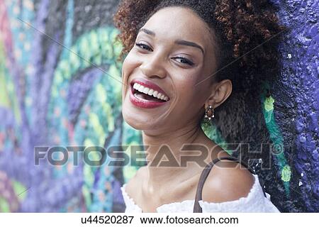 "Portrait of young woman, leaning against wall, smiling, close-up" View Large Photo Image Stock Photo - "Portrait of young woman, leaning against wall, smiling, close-up". Fotosearch
