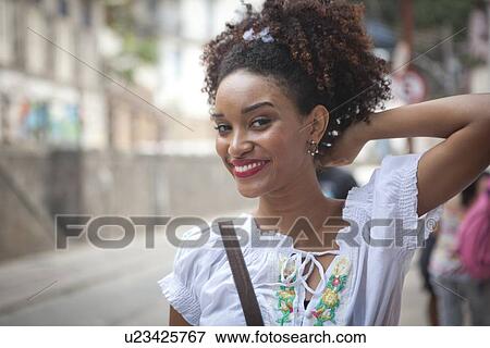 Stock Photo - "Portrait of young woman, looking at camera, smiling". Fotosearch