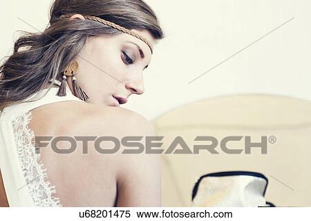 Stock Photography - "Portrait of young woman, looking down, rear view". Fotosearch