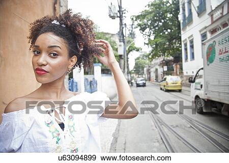 "Portrait of young woman standing in street, close-up" View Large Photo Image Stock Photo - "Portrait of young woman standing in street, close-up". Fotosearch