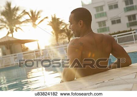 "Rear view of mid adult man standing in sunlit hotel swimming pool, Rio De Janeiro, Brazil" View Large Photo Image Stock Image - "Rear view of mid adult man standing in sunlit hotel swimming pool, Rio De Janeiro, Brazil". Fotosearch