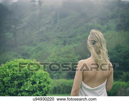 Rear view of young woman wrapped in towel looking out at landscape View Large Photo Image Stock Image - Rear view of young woman wrapped in towel looking out at landscape. Fotosearch