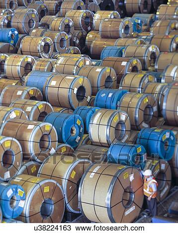 Stock Image - Rolls of steel being stored in port. Fotosearch