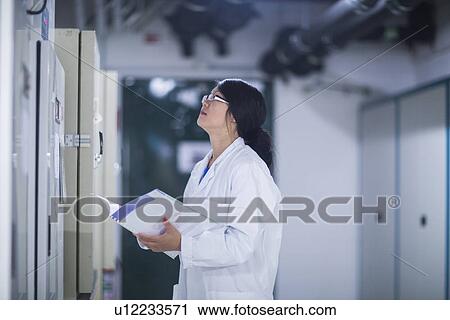 Stock Image - Scientist in control room. Fotosearch
