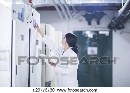 Stock Image - Scientist in control room. Fotosearch