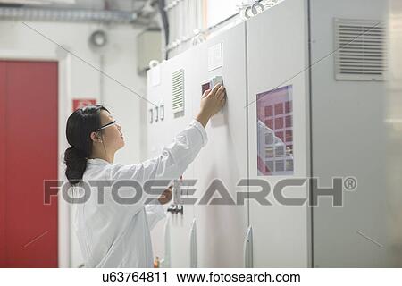 Stock Image - Scientist in control room. Fotosearch