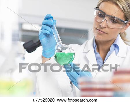Scientist viewing chemical experiment in a laboratory View Large Photo Image Stock Image - Scientist viewing chemical experiment in a laboratory. Fotosearch