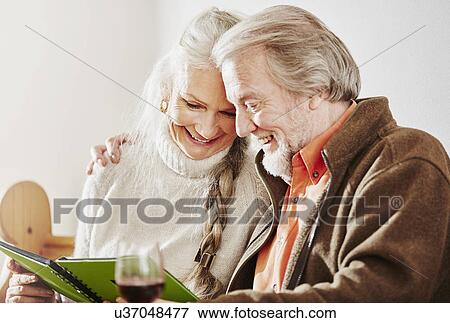 Stock Photo - Senior couple looking at book. Fotosearch