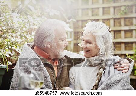 Senior couple wrapped in blanket in garden View Large Photo Image Stock Photo - Senior couple wrapped in blanket in garden. Fotosearch