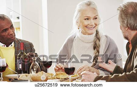Senior friends at dinner table View Large Photo Image Stock Photo - Senior friends at dinner table. Fotosearch