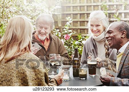 Senior friends drinking and playing cards in garden View Large Photo Image Stock Image - Senior friends drinking and playing cards in garden. Fotosearch