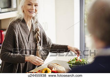 Stock Photo - Senior woman preparing food in kitchen. Fotosearch