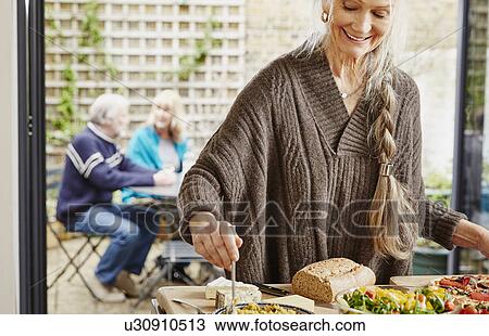 Stock Image - Senior woman preparing food. Fotosearch