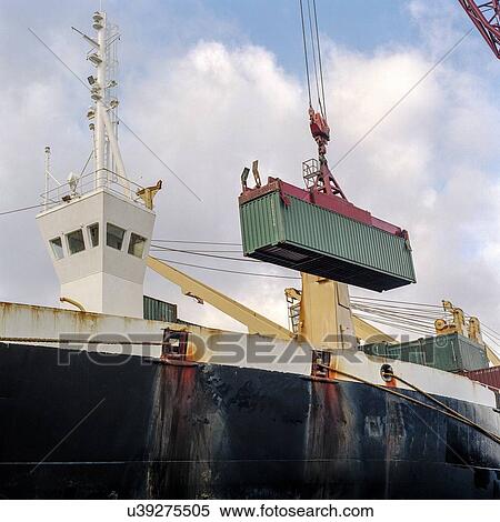 Shipping container being lowered by crane onto ship in port View Large Photo Image Stock Photography - Shipping container being lowered by crane onto ship in port. Fotosearch