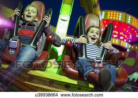 Sister and brother on fairground ride at night View Large Photo Image Picture - Sister and brother on fairground ride at night. Fotosearch