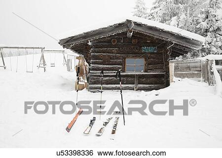 Stock Photograph - "Skis and ski poles outside log cabin, Tyrol, Austria". Fotosearch