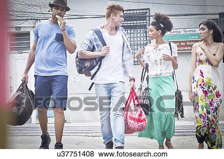 "Small group of people walking together, carrying travel bags" View Large Photo Image Stock Photo - "Small group of people walking together, carrying travel bags". Fotosearch