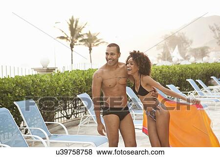 Stock Photo - "Smiling couple laughing at hotel poolside, Rio De Janeiro, Brazil". Fotosearch