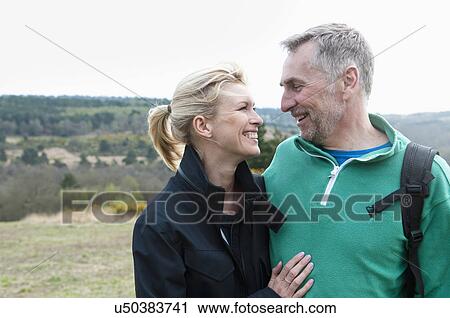 Smiling hiking couple in rural landscape View Large Photo Image Stock Image - Smiling hiking couple in rural landscape. Fotosearch