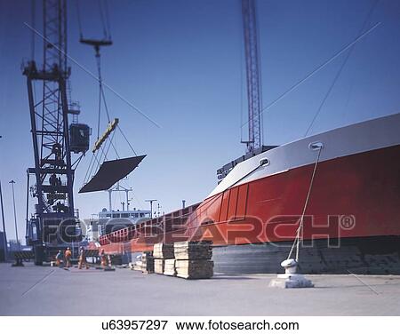 Stock Photo - Stevedores loading steel onto ship in port. Fotosearch