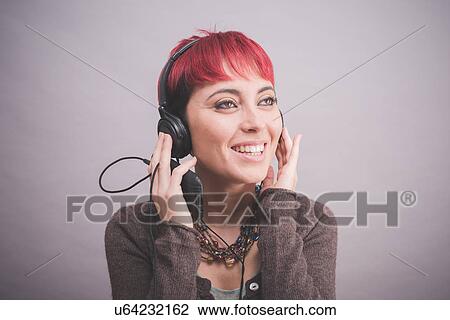 Studio portrait of young woman with short pink hair listening to headphones View Large Photo Image Stock Image - Studio portrait of young woman with short pink hair listening to headphones. Fotosearch