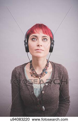 Studio portrait of young woman with short pink hair wearing headphones View Large Photo Image Stock Image - Studio portrait of young woman with short pink hair wearing headphones. Fotosearch