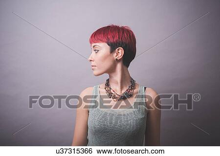 Studio portrait of young woman with short pink hair looking over her shoulder View Large Photo Image Stock Photograph - Studio portrait of young woman with short pink hair looking over her shoulder. Fotosearch