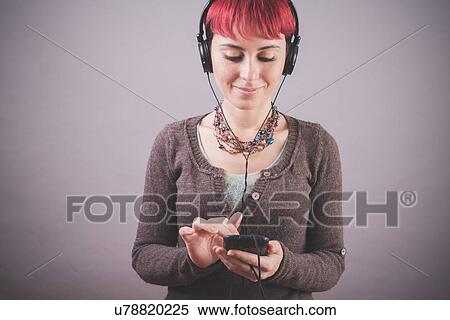Studio portrait of young woman with short pink hair choosing music on smartphone View Large Photo Image Stock Photography - Studio portrait of young woman with short pink hair choosing music on smartphone. Fotosearch