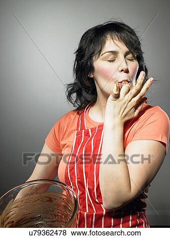 Studio shot of young woman with eyes closed licking chocolate from fingers View Large Photo Image Stock Photo - Studio shot of young woman with eyes closed licking chocolate from fingers. Fotosearch