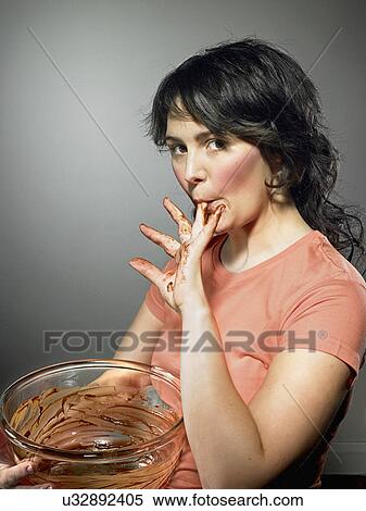 Studio shot of young woman with mixing bowl licking chocolate from fingers View Large Photo Image Stock Photography - Studio shot of young woman with mixing bowl licking chocolate from fingers. Fotosearch