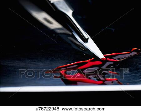 Stock Photo - Surgeons scalpel sitting in tray with blood. Fotosearch