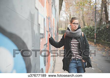Stock Photo - Teenager leaning against graffiti wall. Fotosearch