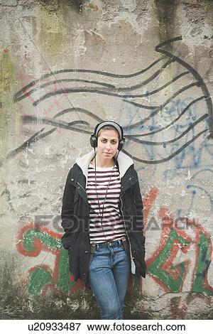 Teenager with headphones by graffiti wall View Large Photo Image Stock Photo - Teenager with headphones by graffiti wall. Fotosearch