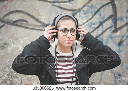 Teenager with headphones by graffiti wall View Large Photo Image Stock Photography - Teenager with headphones by graffiti wall. Fotosearch
