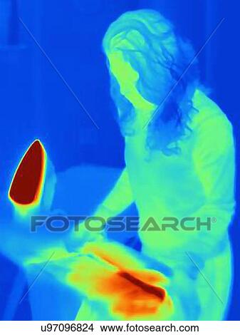 Picture - Thermal image of mature woman ironing. Fotosearch
