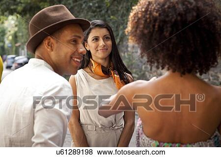 "Three friends standing together, talking, rear view" View Large Photo Image Stock Photo - "Three friends standing together, talking, rear view". Fotosearch