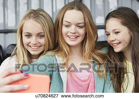 Three girls posing for smartphone selfie in shelter View Large Photo Image Stock Photo - Three girls posing for smartphone selfie in shelter. Fotosearch