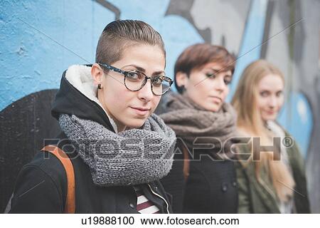 Stock Image - Three sisters by graffiti wall. Fotosearch