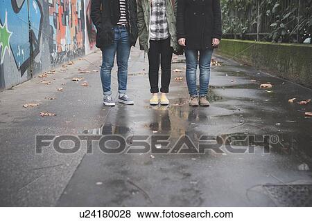 Stock Photo - Three sisters by graffiti wall. Fotosearch