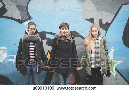 Three sisters by graffiti wall View Large Photo Image Stock Photo - Three sisters by graffiti wall. Fotosearch