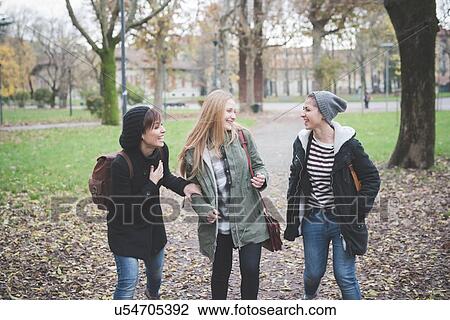 Three sisters chatting in park View Large Photo Image Stock Image - Three sisters chatting in park. Fotosearch