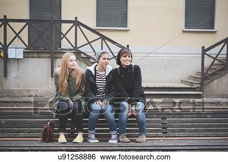 Three sisters sitting on park bench View Large Photo Image Stock Photograph - Three sisters sitting on park bench. Fotosearch