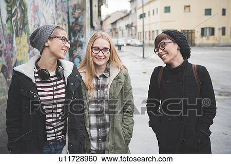 Three sisters walking by graffiti wall View Large Photo Image Stock Image - Three sisters walking by graffiti wall. Fotosearch