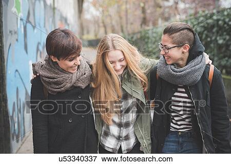 Three sisters walking by graffiti wall View Large Photo Image Stock Photo - Three sisters walking by graffiti wall. Fotosearch