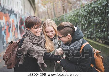Three sisters walking by graffiti wall View Large Photo Image Stock Photograph - Three sisters walking by graffiti wall. Fotosearch