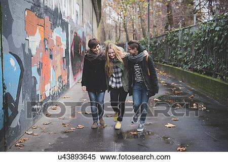 Three sisters walking by graffiti wall View Large Photo Image Stock Photography - Three sisters walking by graffiti wall. Fotosearch