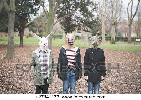 Stock Photo - Three sisters wearing animal masks posing in park. Fotosearch