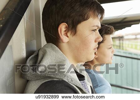 Two boys looking out from shelter View Large Photo Image Stock Photo - Two boys looking out from shelter. Fotosearch