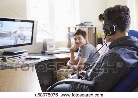 Stock Photograph - Two boys playing on computer game. Fotosearch