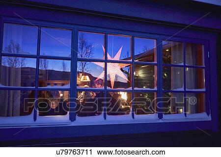 Stock Image - Two brothers looking out of cabin Christmas window at night. Fotosearch